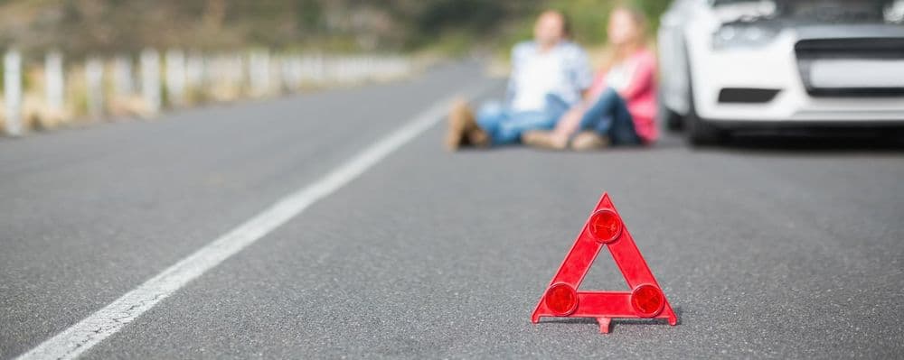 Roadside breakdown scene with warning triangle, representing roadside/excess cover
