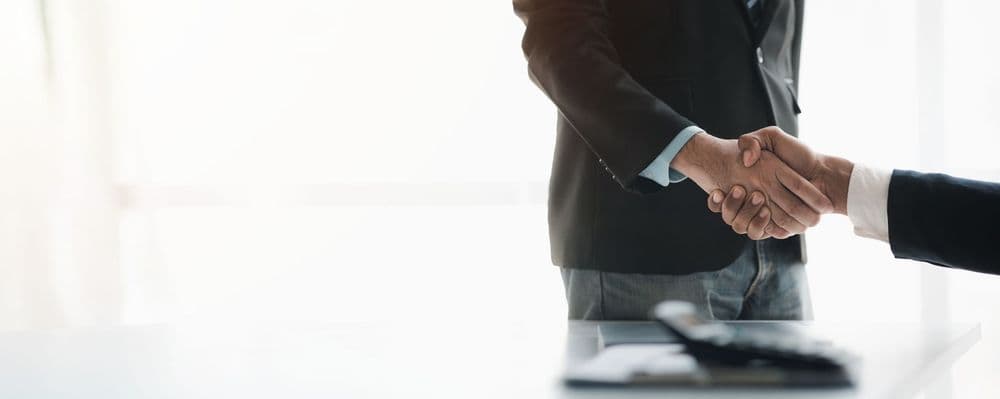 Business handshake representing a trusted, regulated insurance partnership